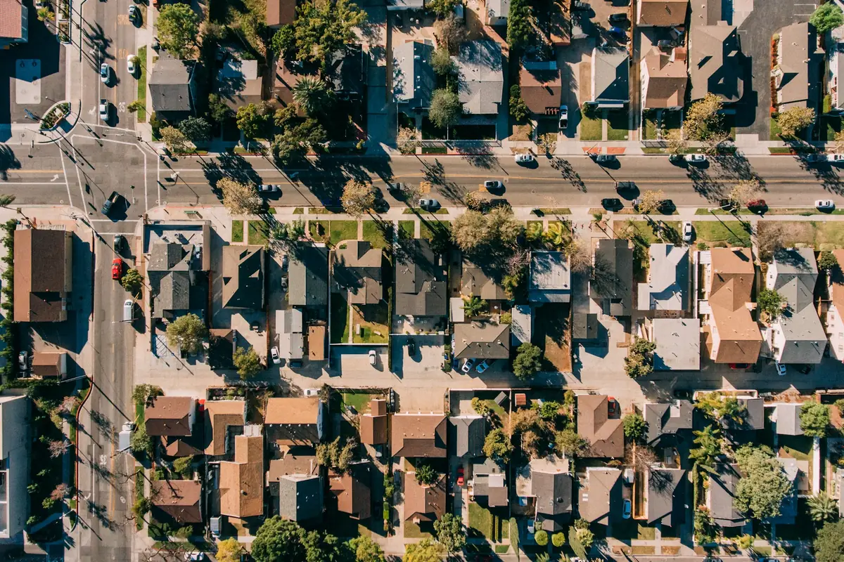 A California tract neighborhood seen from above, with rows of roofs and streets